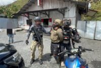 Personel Satgas Damai Cartenz saat mengamankan Konara Enumbi, anggota KKB Yambi, di Puncak Jaya, Papua Tengah. (Dok-Polri)