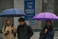 Warga berteduh saat hujan turun di kawasan Jakarta Selatan, Kamis (7/8/2025). (Foto/onlinews)
