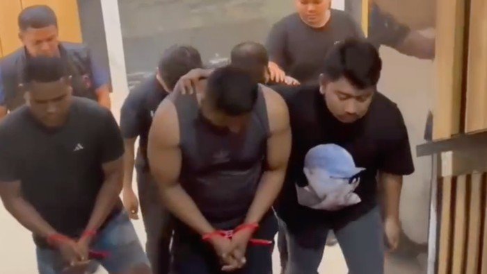 Polisi menggiring tiga pelaku penculikan Kepala KCP Bank BRI di Polda Metro Jaya dengan tangan terikat kabel ties. (Dok-Istimewa)
