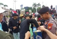 Personel Samapta Polda Metro Jaya membagikan air mineral dan roti kepada peserta aksi buruh di depan Gedung DPR/MPR RI, Jakarta, Kamis (28/8/2025). Aksi simpatik ini menjadi wujud pelayanan humanis Polri kepada masyarakat. (Dok-PMJ)