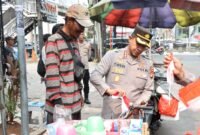 Kapolres Metro Jakarta Barat Kombes Pol Twedi Aditya Bennyahdi membagikan Bendera Merah Putih kepada pengendara di Jalan Tomang Raya dalam rangka menyambut HUT ke-80 RI, Kamis (7/8/2025). (Dok-Istimewa)