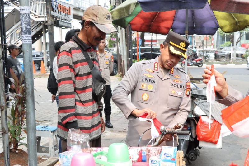 Kapolres Metro Jakarta Barat Kombes Pol Twedi Aditya Bennyahdi membagikan Bendera Merah Putih kepada pengendara di Jalan Tomang Raya dalam rangka menyambut HUT ke-80 RI, Kamis (7/8/2025). (Dok-Istimewa)